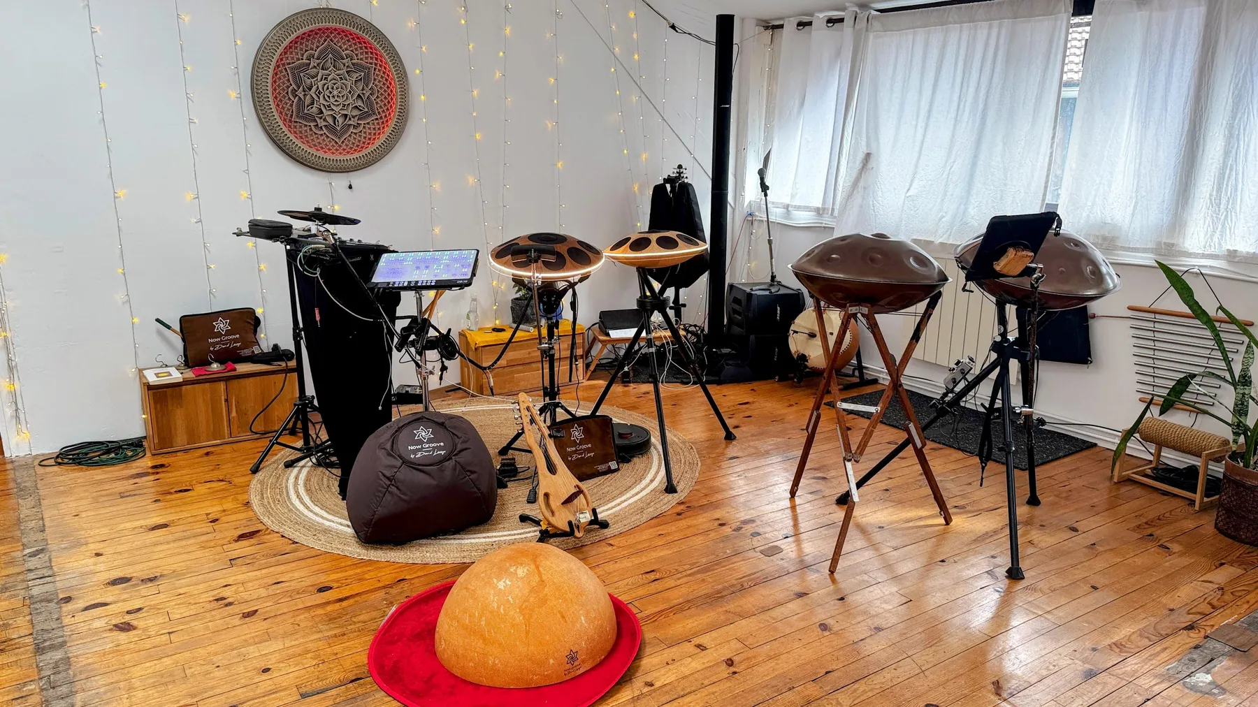 Les instruments installés au showroom avant l’arrivée du public : deux handpans acoustiques Yishama sur trépieds, deux handpans électroniques Neotone avec leur écran, une calebasse posée sur un tapis rouge, le tout sur parquet ancien.